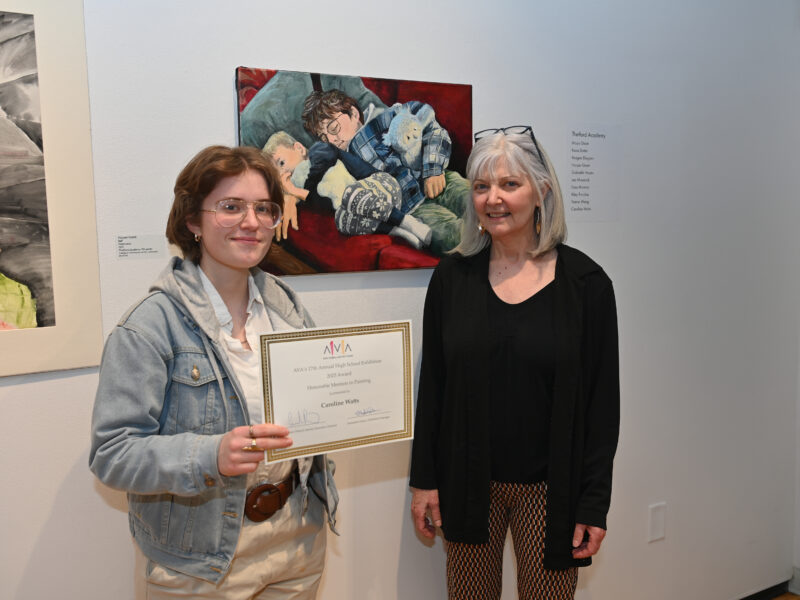 Student Caroline Watts and art teacher Karyn Neubauer pose with Caroline's painting and honorable mention certificate.